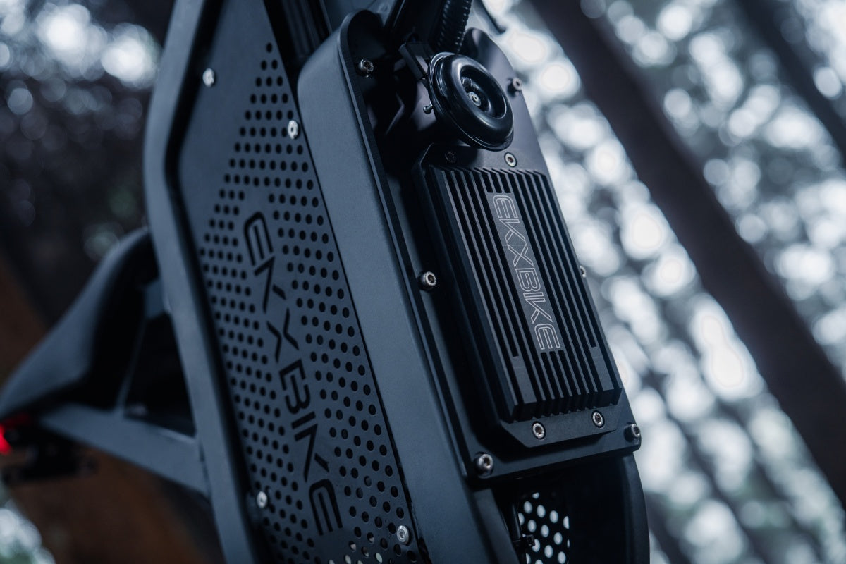 Close-up of the EKX X21 Max removable 60V 30Ah lithium-ion battery pack installed in the frame, highlighting the 1800Wh capacity and durable heat-dissipating casing for extended range.