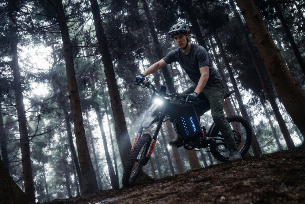 The EKX GTS X22 off-road e-motorcycle ridden through a forest, featuring its reliable 72V 30Ah battery that delivers a 55-mile range.